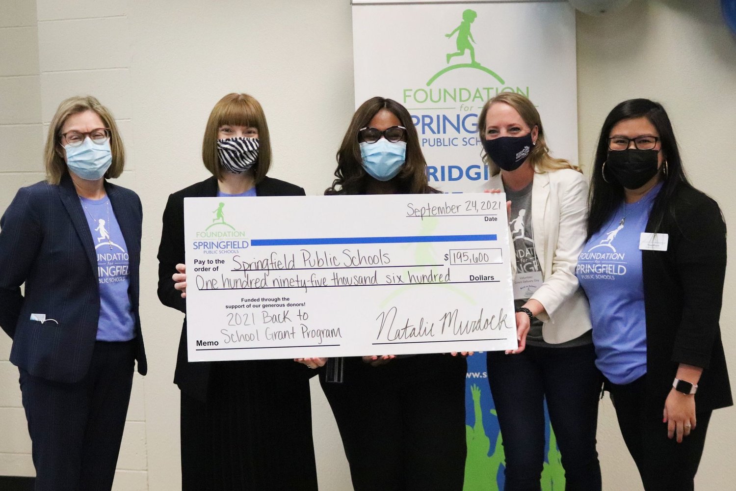 SPS Superintendent Grenita Lathan, center, and SPS board member Danielle Kincaid, second from right, accept a check from Foundation for SPS officials, from left, Jennifer McClure, Natalie Murdock and Tina Pham.